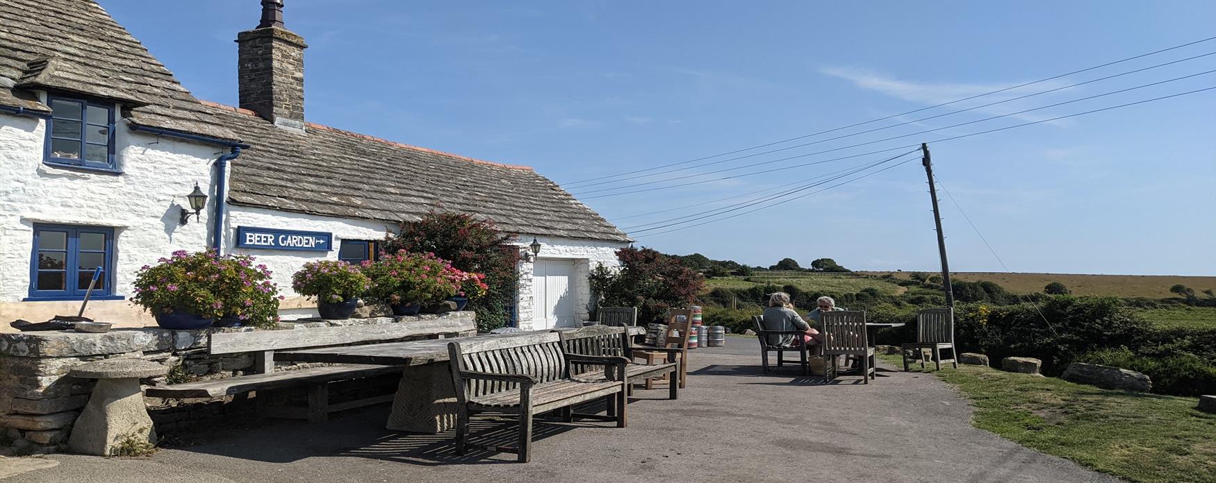 A white thatched cottage pub with a beer garden overlooking the hills and sea of Worth Matravers, Dorset, UK.