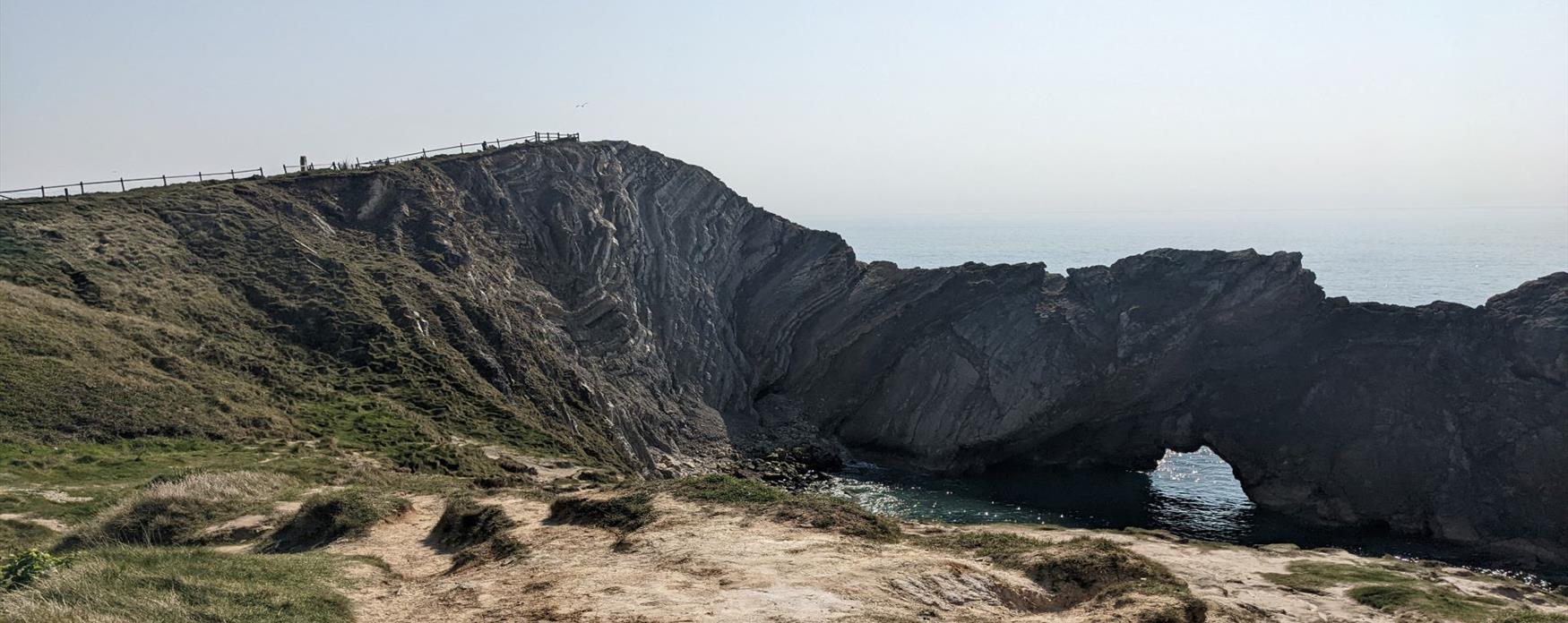 A view of the Lulworth Crumple and Stair Hole from the land side. The rocks in the Lulworth Crumple have been folded up in a 'v' shape under considerable force.